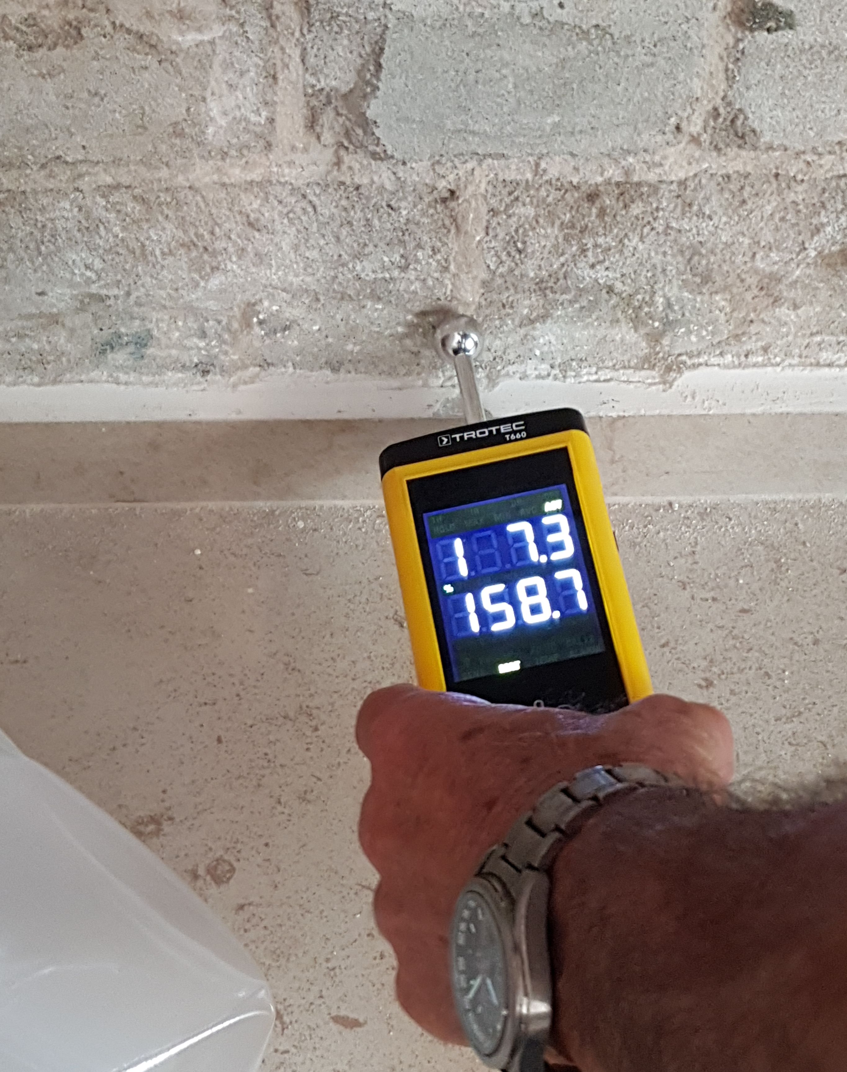 Moisture meter checking a building surface